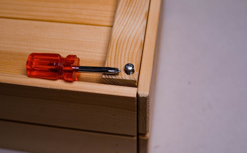 Handyman carefully testing a wall outlet in a Madison home